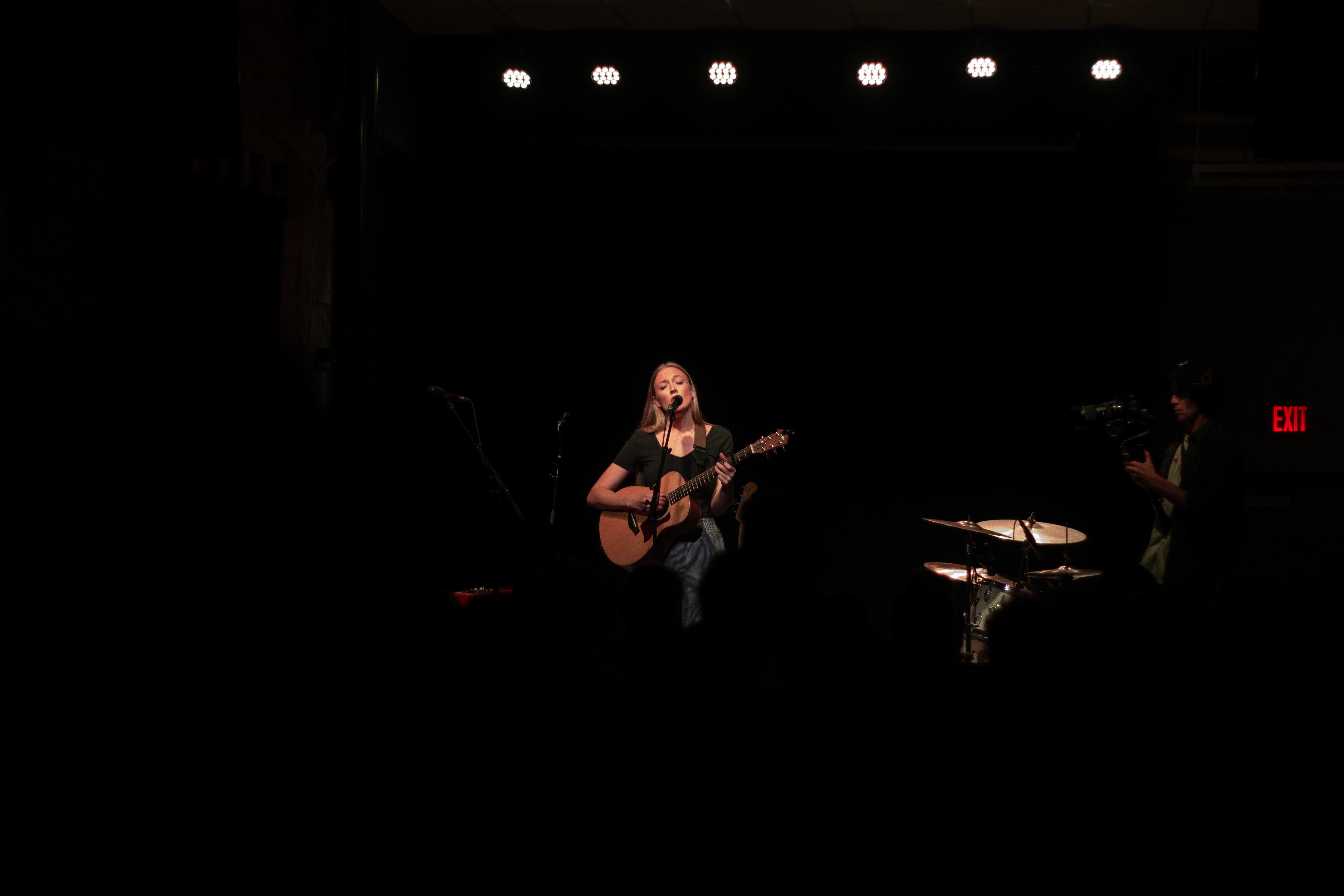 Picture of a guitar player singing into a mic