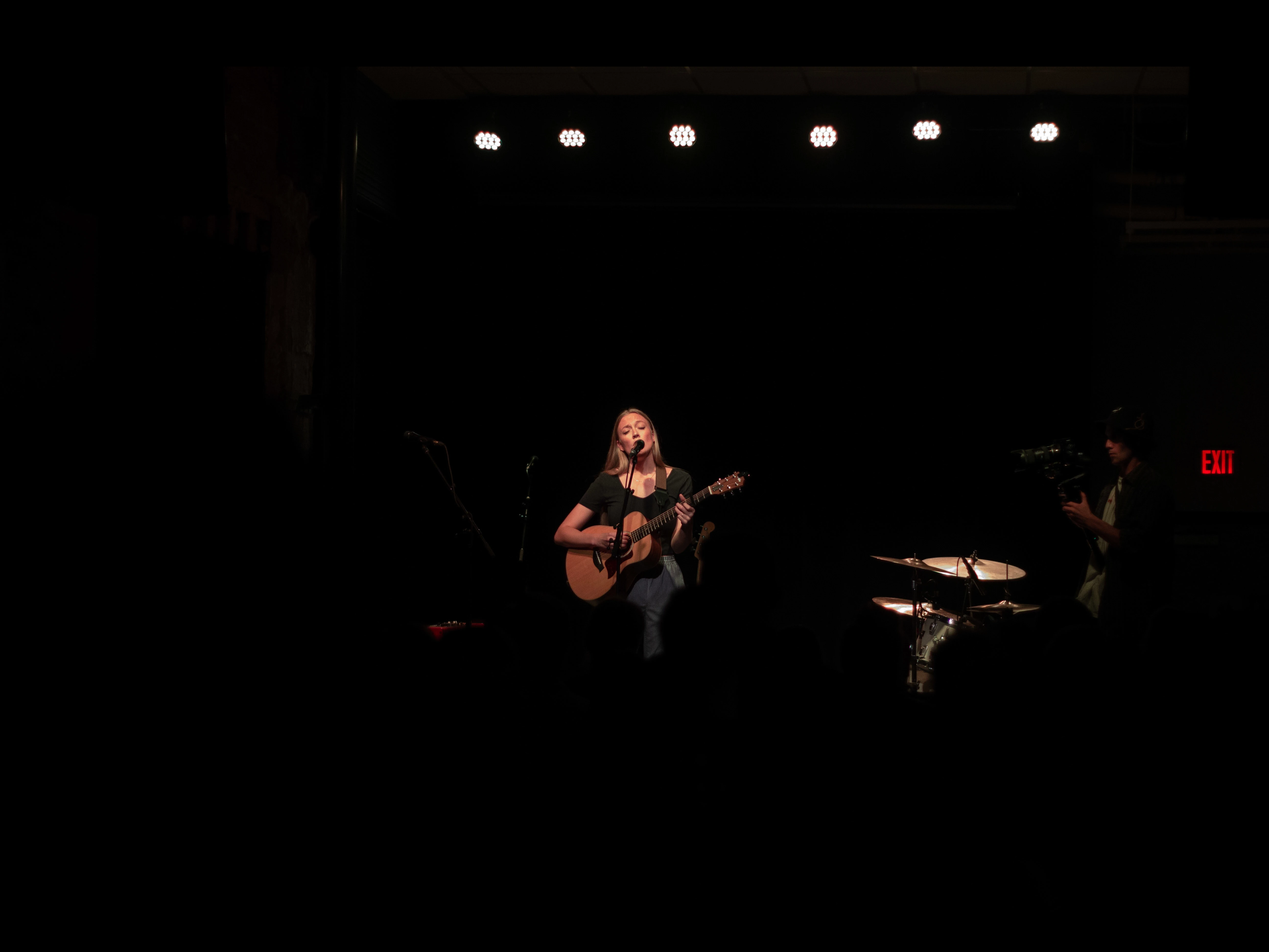 Picture of a guitar player singing into a mic